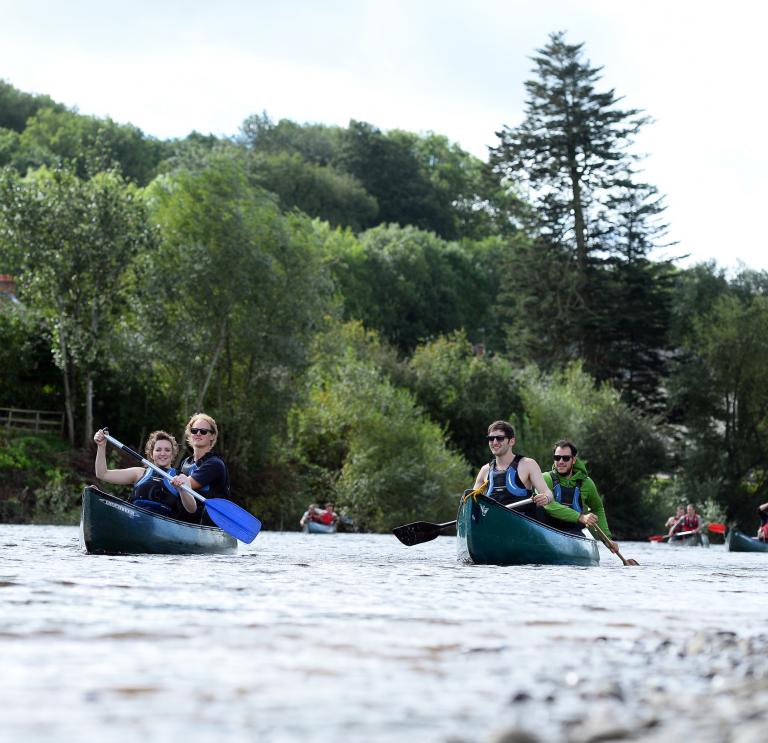 Image of a group of people canoeing open boats on the river Wye