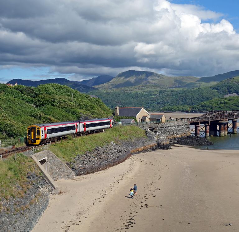 A train near Barmouth viaduct travelling between the mountains and coast.