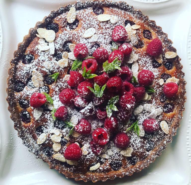 Fresh raspberry and almond flaked fruit tart, dusted with icing sugar. 