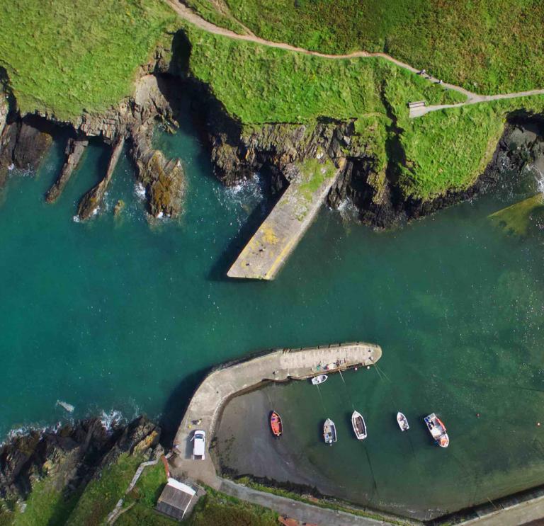 Aerial view of Porthgain Harbour and some small boats.
