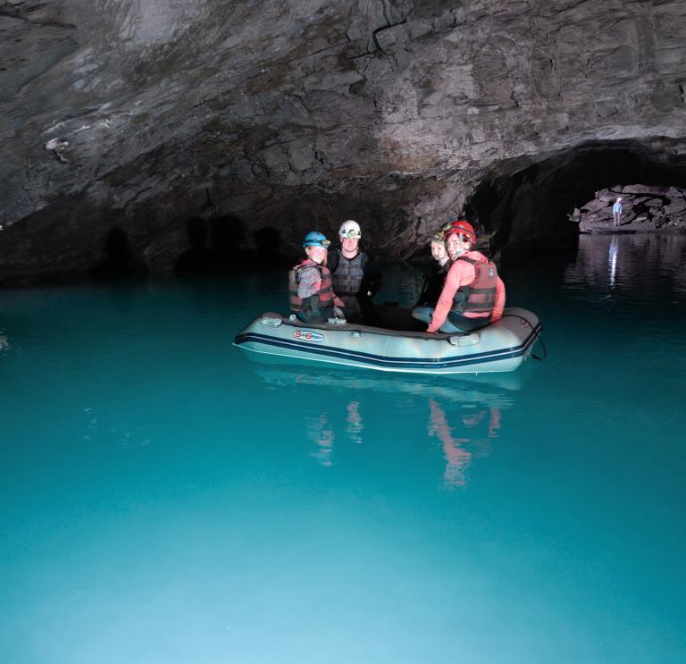 Image of a group of people floating in a boat on an underground lake