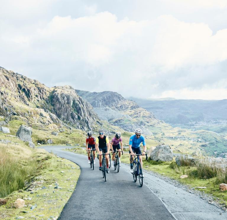 Four cyclists on a narrow mountainous road