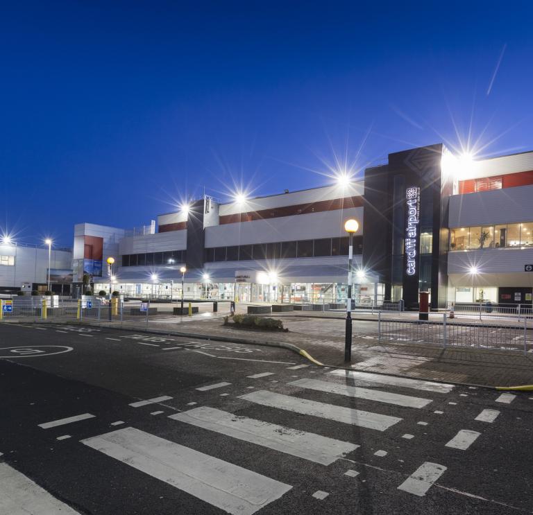 External shot of Cardiff Airport brightly lit at night.