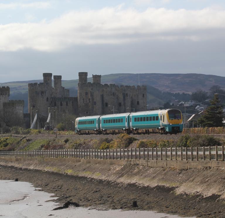 A mainline train by a castle.