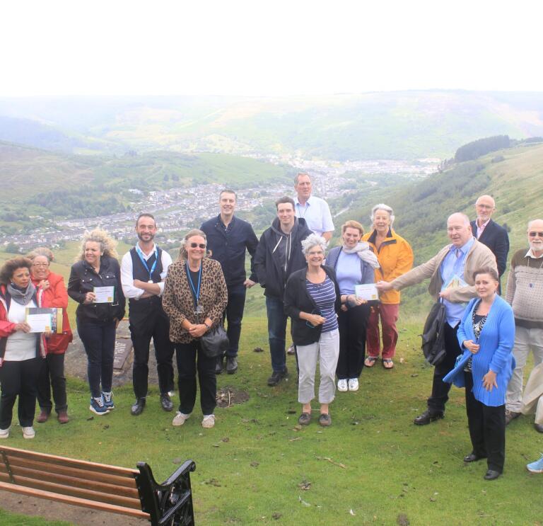A group of people standing on a mountain on a tour of the valleys.