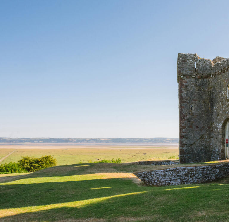 A ruined castle overlooking an estuary.