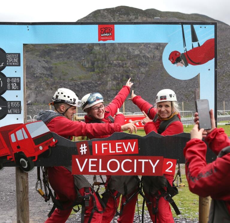 A group posing in a camera frame after travelling down a zip wire.