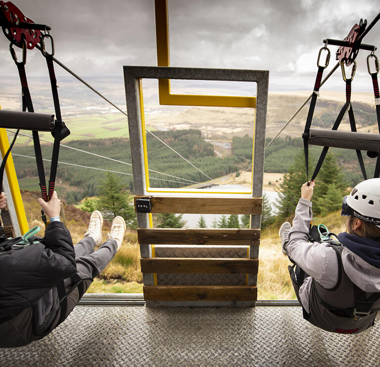 A woman and a child ready to go down a zip wire.