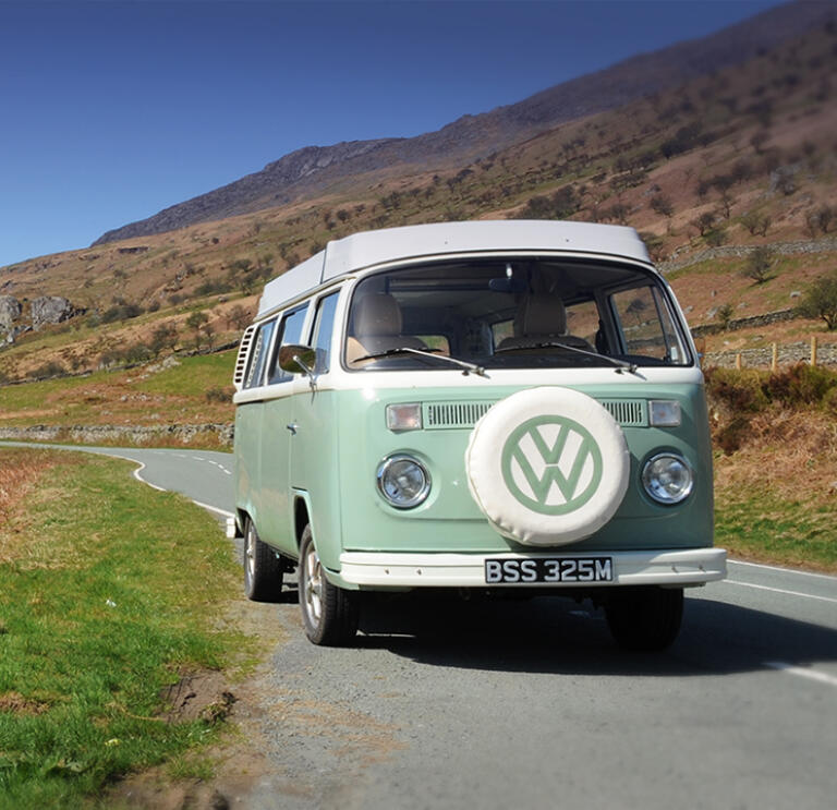 VW campervan on a road alongside a lake in Snowdonia