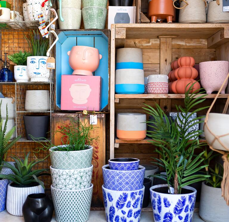Inside a shop with colourful plant pots on display.