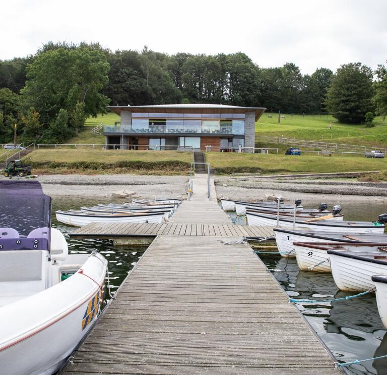 boats and jetty, with visitor centre in background.
