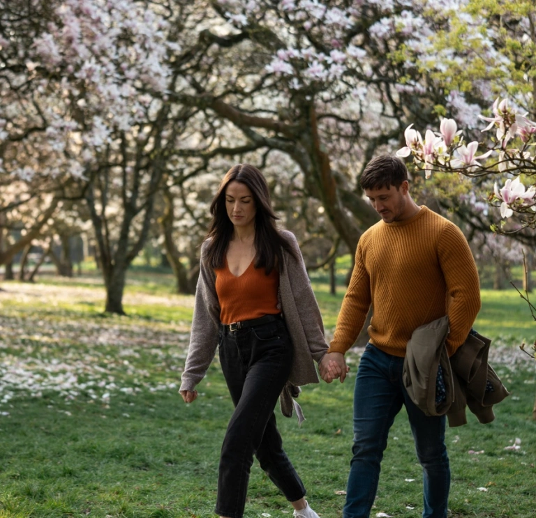 couple walking near blossoming trees in Bute Park, Cardiff