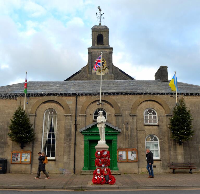 town hall with statue and Christmas trees.