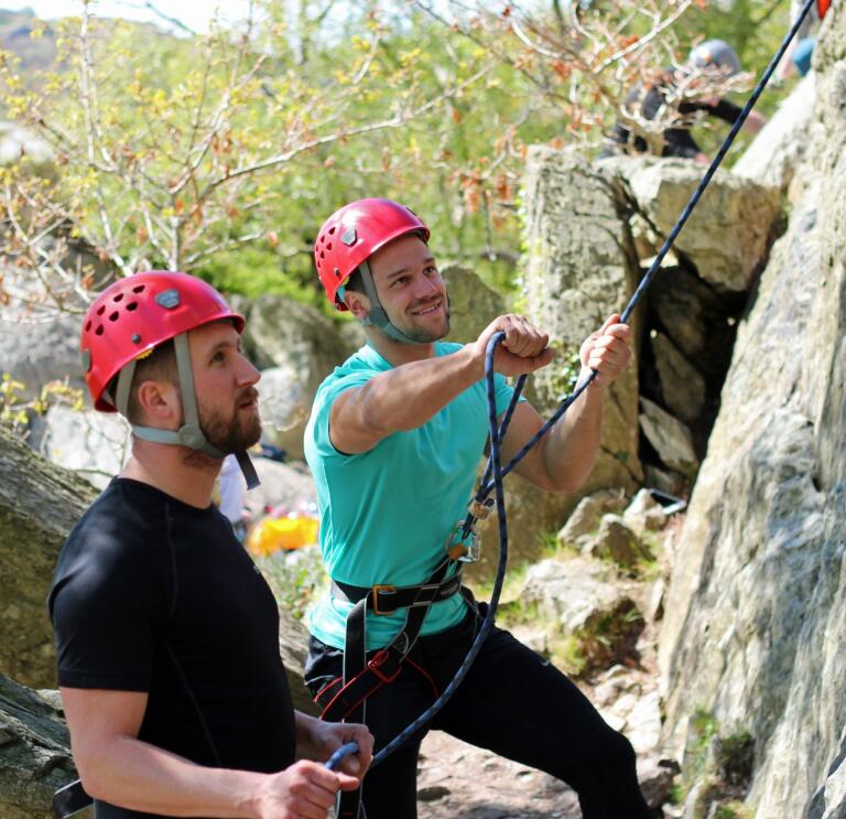 instructor showing man how to use ropes.