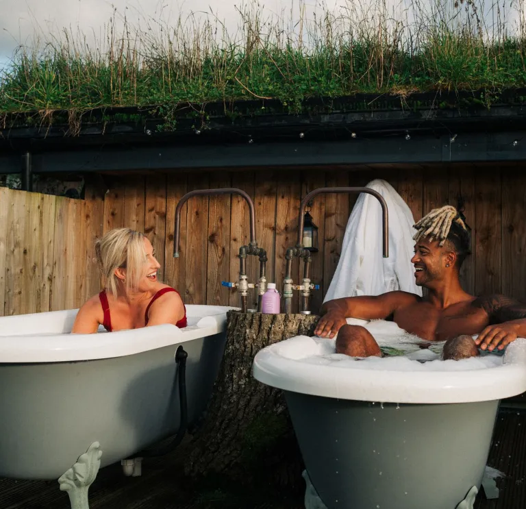 woman and man in outdoor bath tubs.