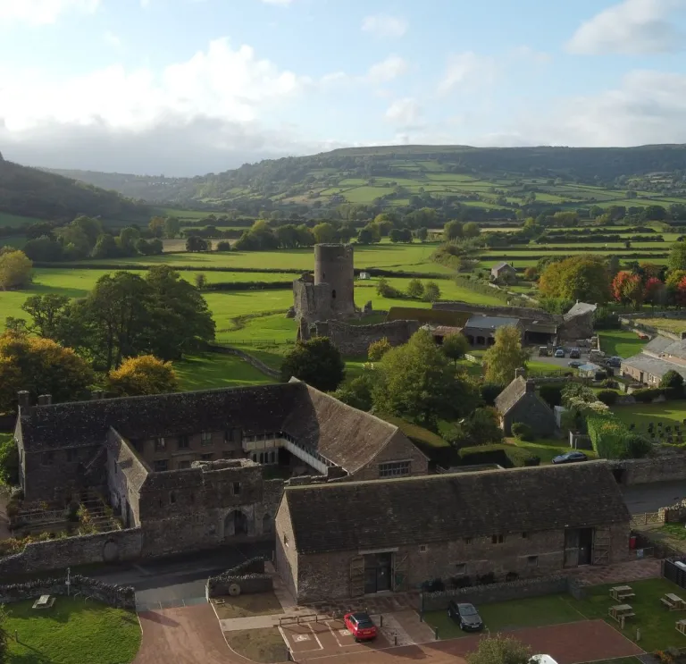 A large group of old buildings around a semi-ruined castle tower.