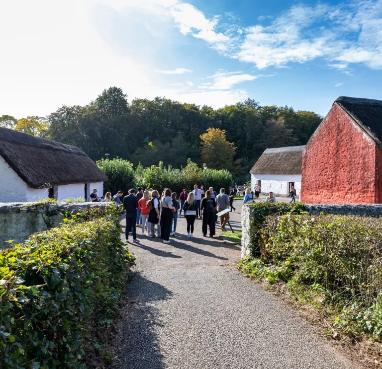 A group of people walking around an outdoor living museum.
