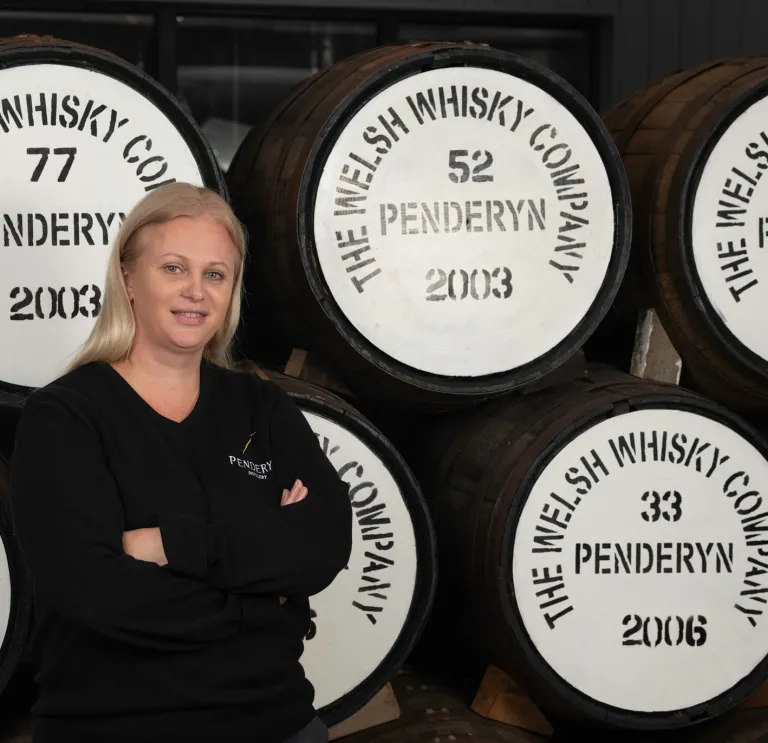 woman stood near barrels of whisky.