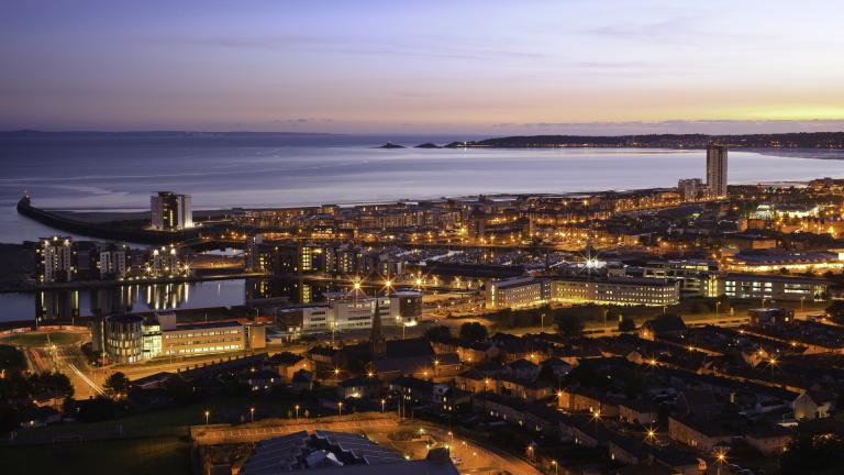 Aerial view over Swansea town at early evening toward Mumbles Head.