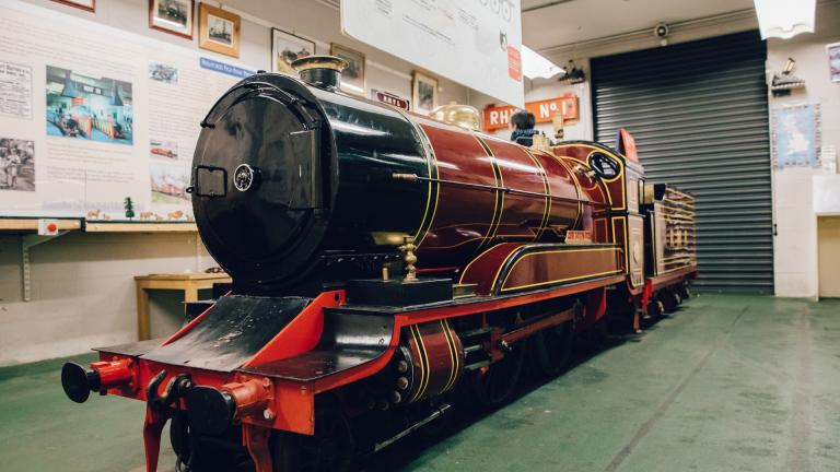 A red locomotive inside the museum at Rhyl Miniature Railway.