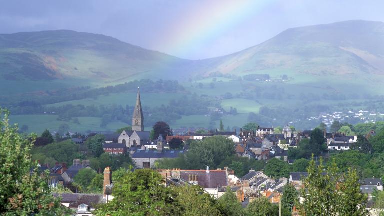 view of town , hills beyond and a rainbow.