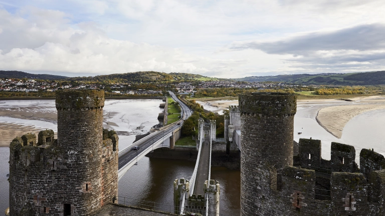 Eine Straßenbrücke und eine Eisenbahnbrücke, die zwischen zwei Burgtürmen verläuft.