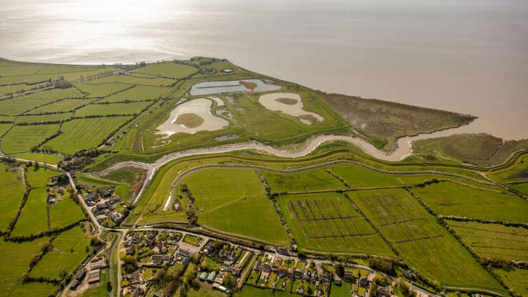 Aerial view of green landscape and waterways next to a river. 