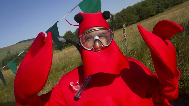man in lobster fancy dress outfit wearing snorkel.