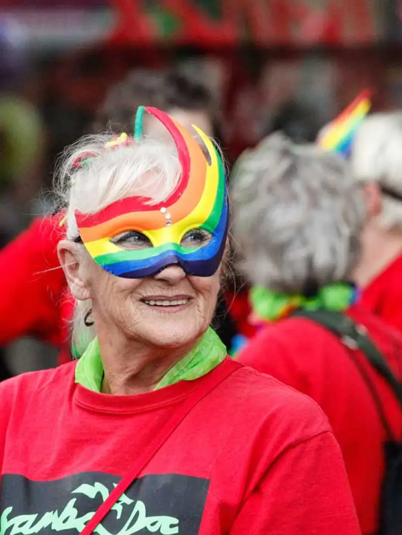 Woman smiling in a colourful eye mask