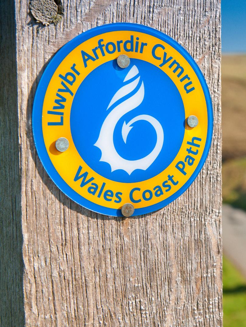 Ein Schild an einem Pfosten mit der Aufschrift Wales Coast Path.