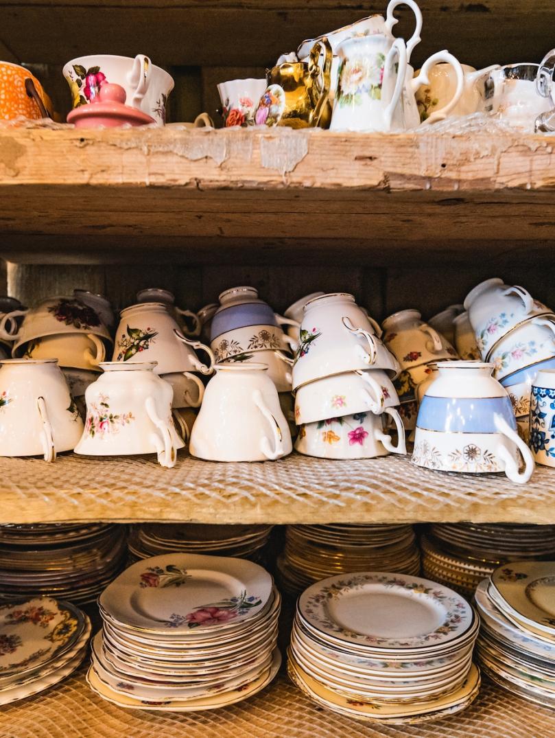 Rows of cups and saucers on shelves in a coffee shop