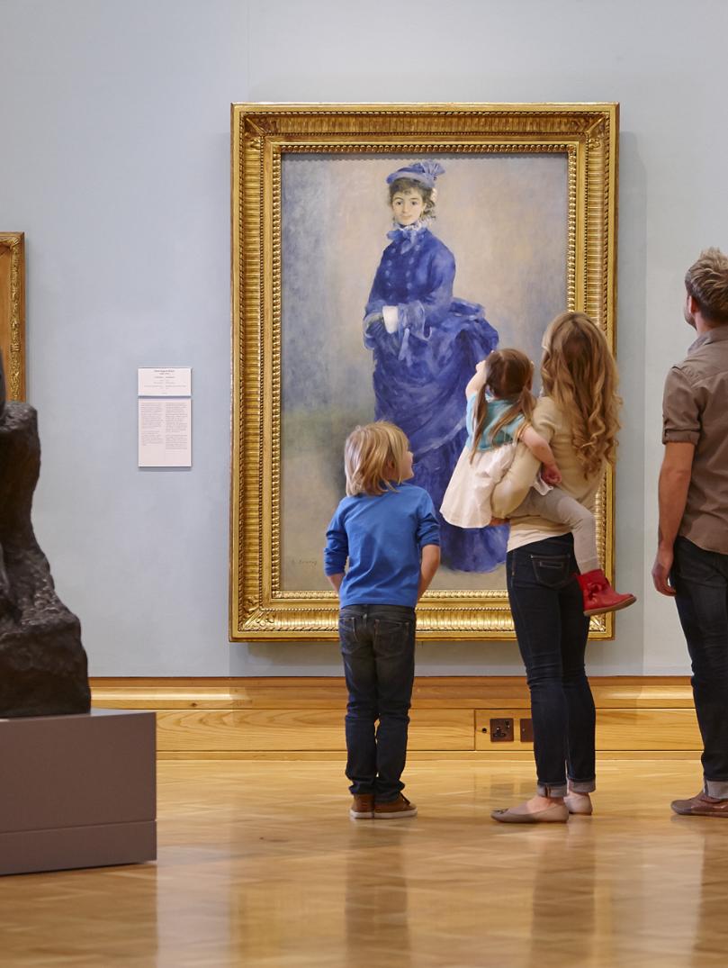 Eine Familie betrachtet ein Gemälde in der Galerie.