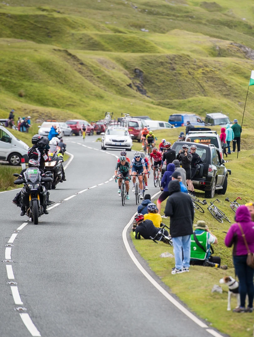 Cyclists and spectators lining a mountain road.