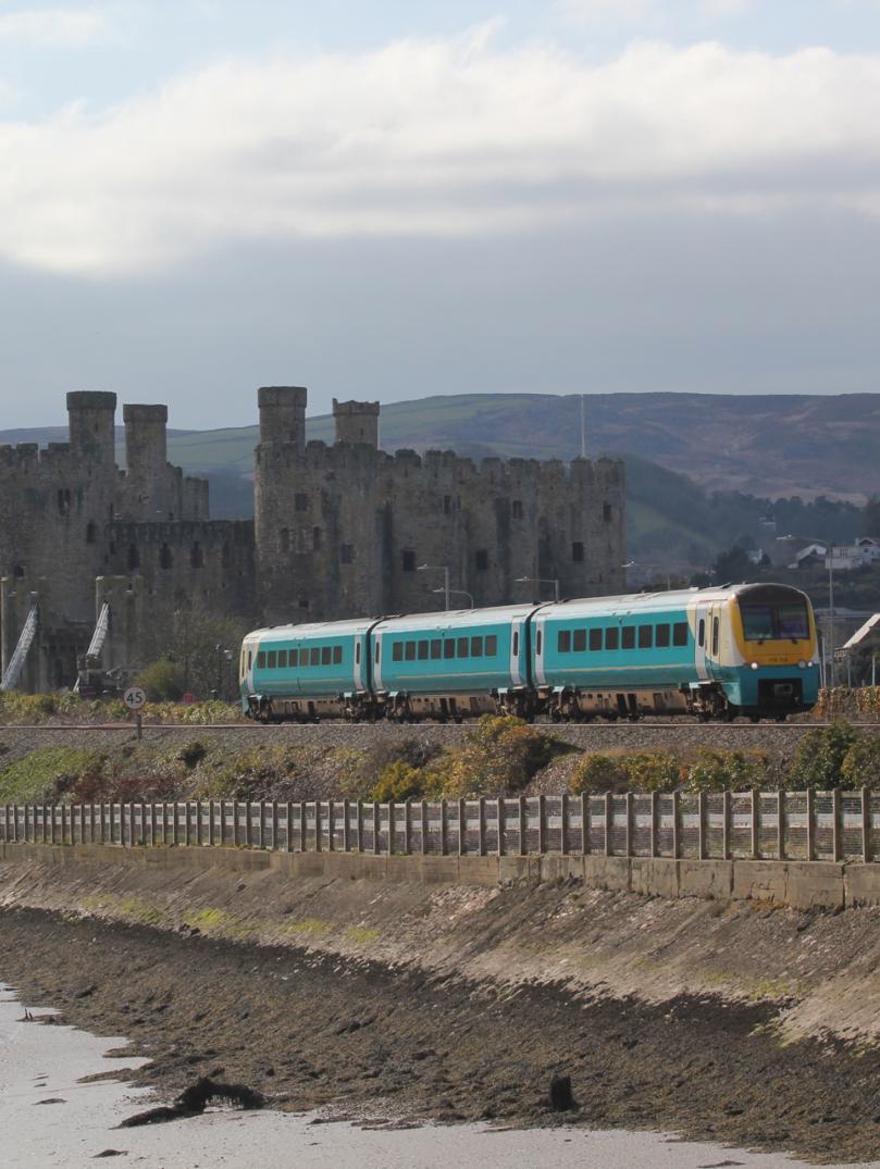 A mainline train by a castle.