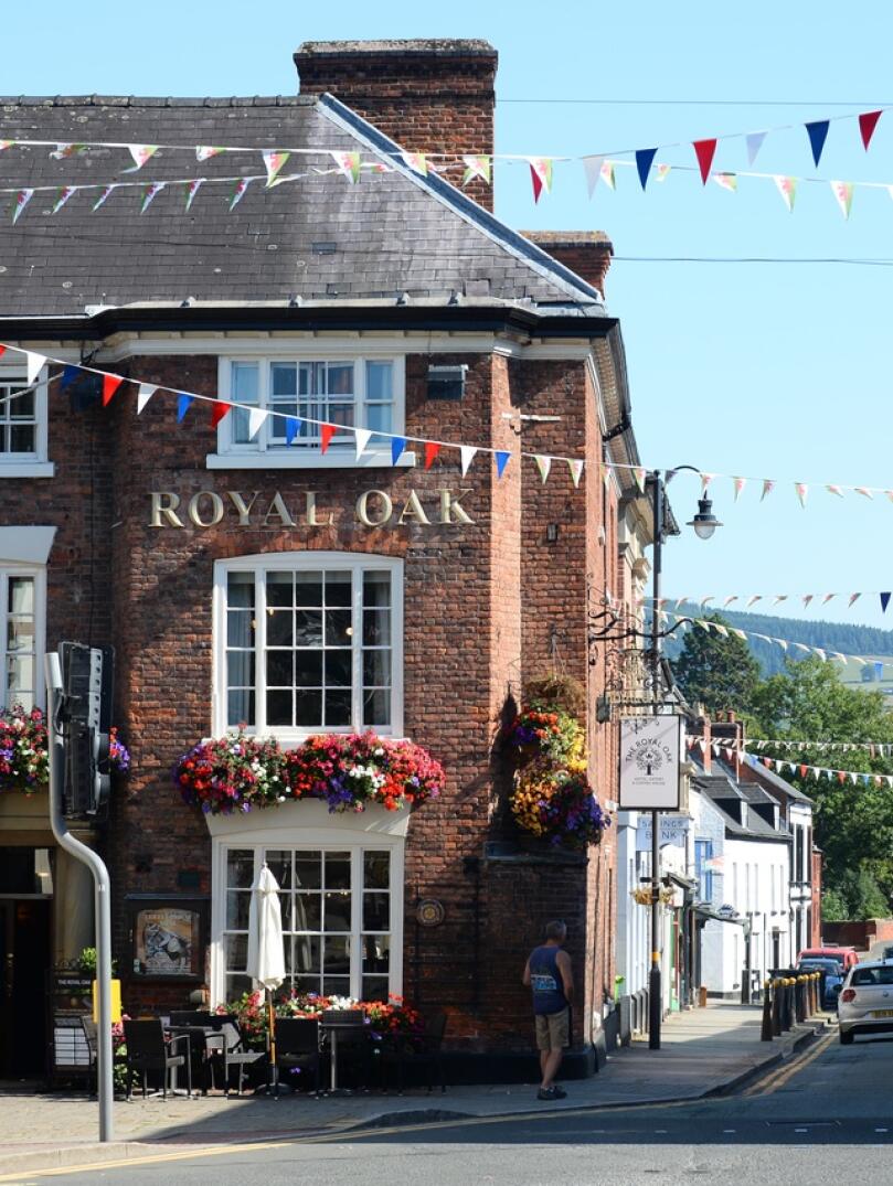 Exterior of The Royal Oak pub on the corner of a street in Welshpool, decorated with red, white and bluebunting