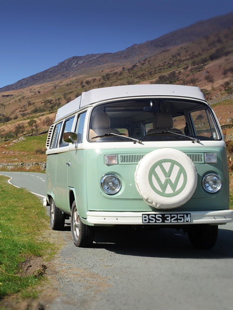 VW campervan on a road alongside a lake in Snowdonia