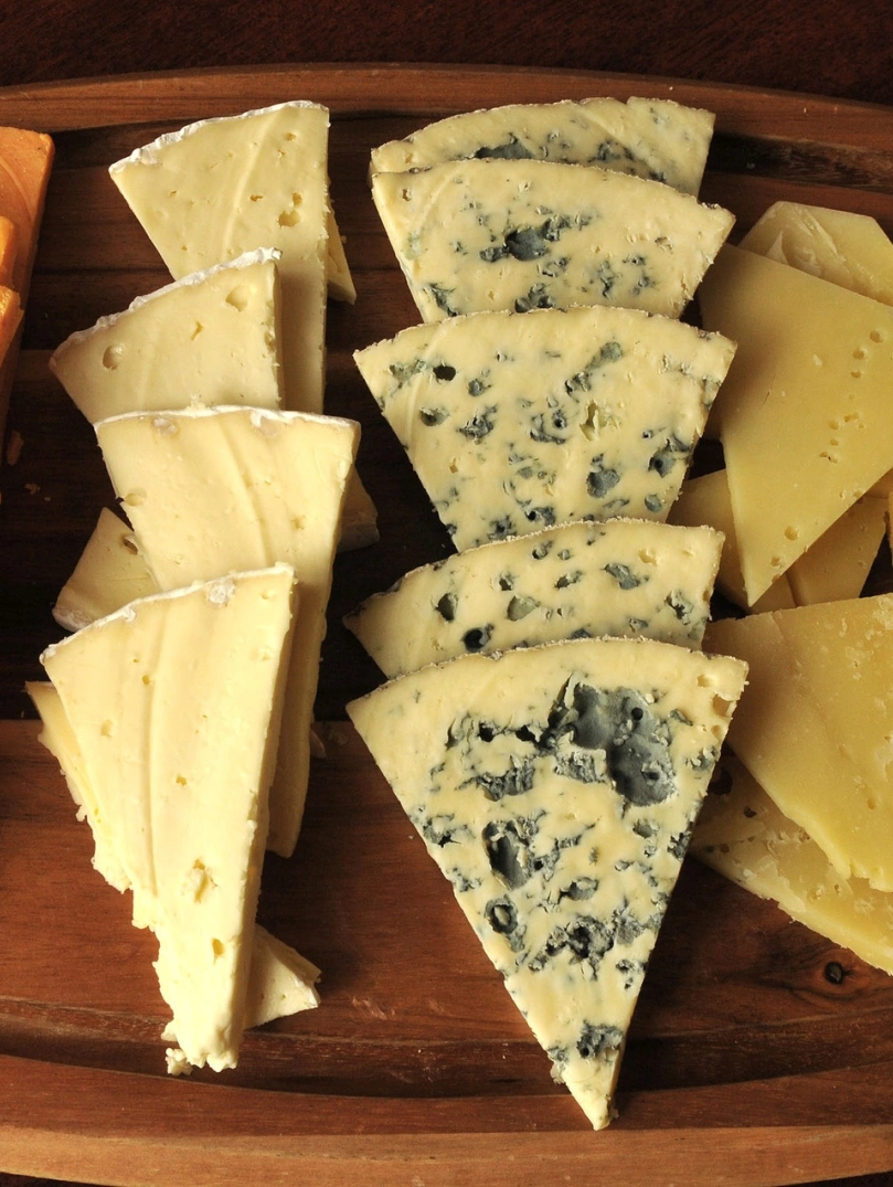 A selection of cheeses on a wooden board.