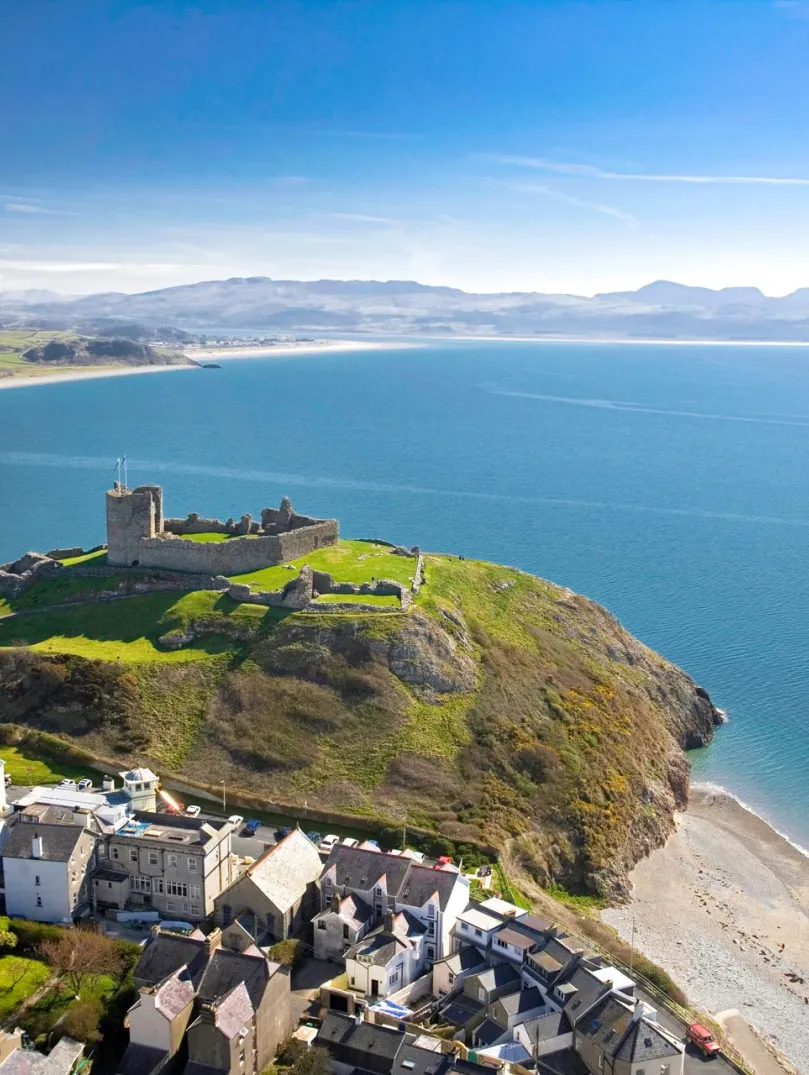 aerial view of Criccieth Castle and the blue sea of Tremadog Bay.
