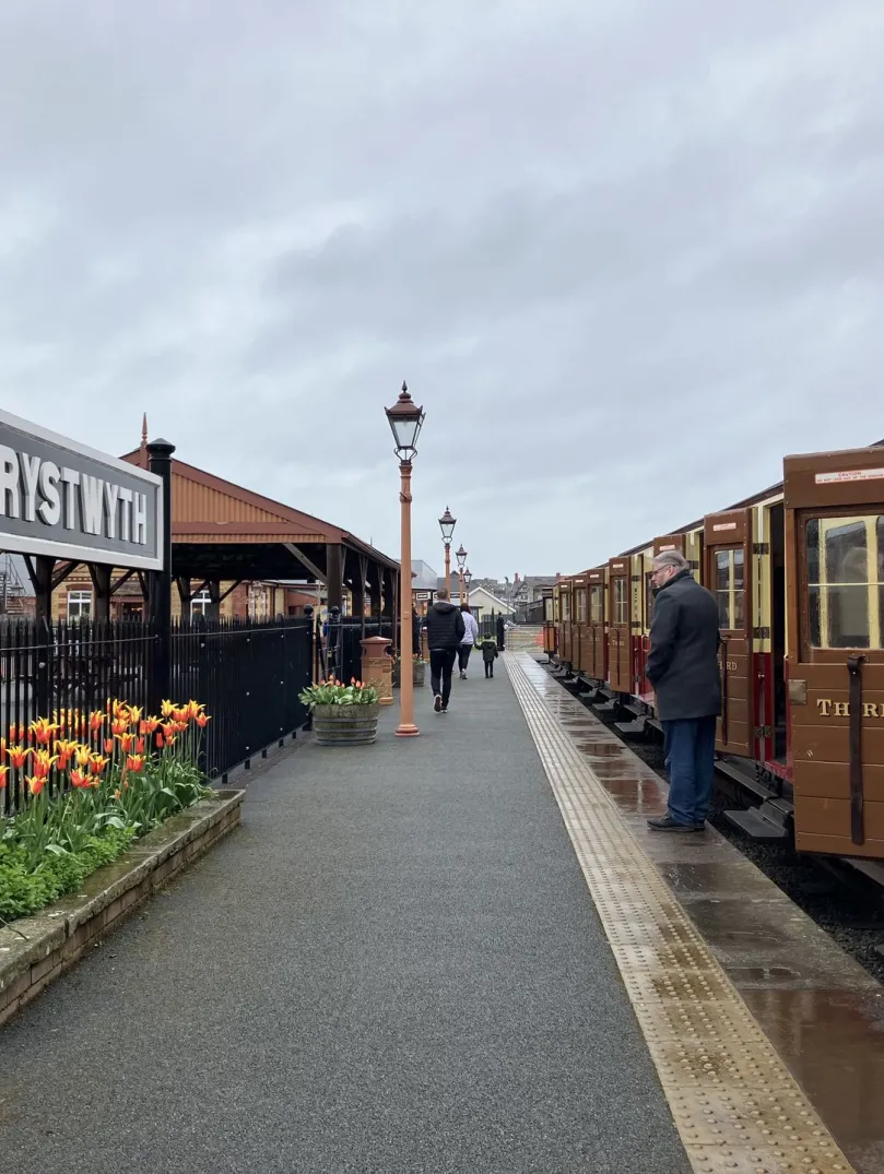 A train in a narrow-gauge railway platform on a rainy day.