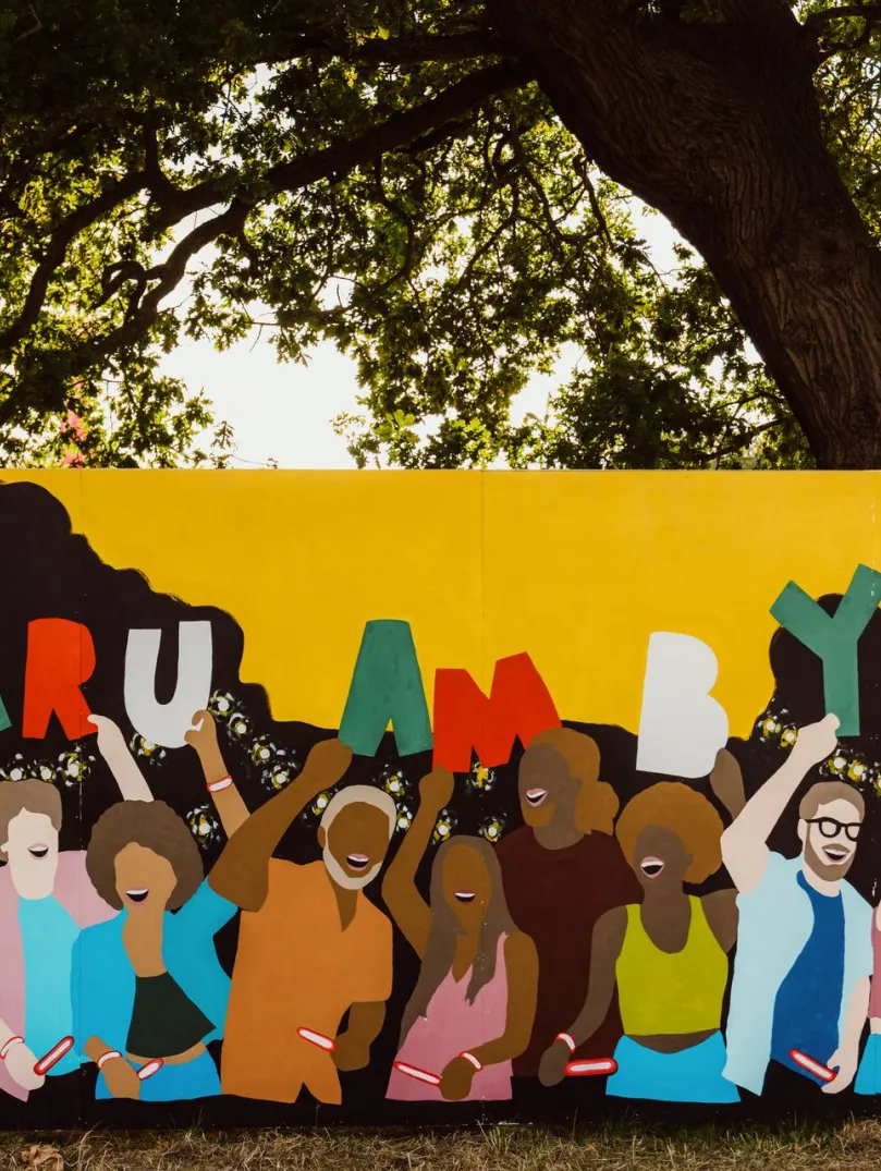 A colourful mural with loads of people holding up 'Cymru am byth' letters.