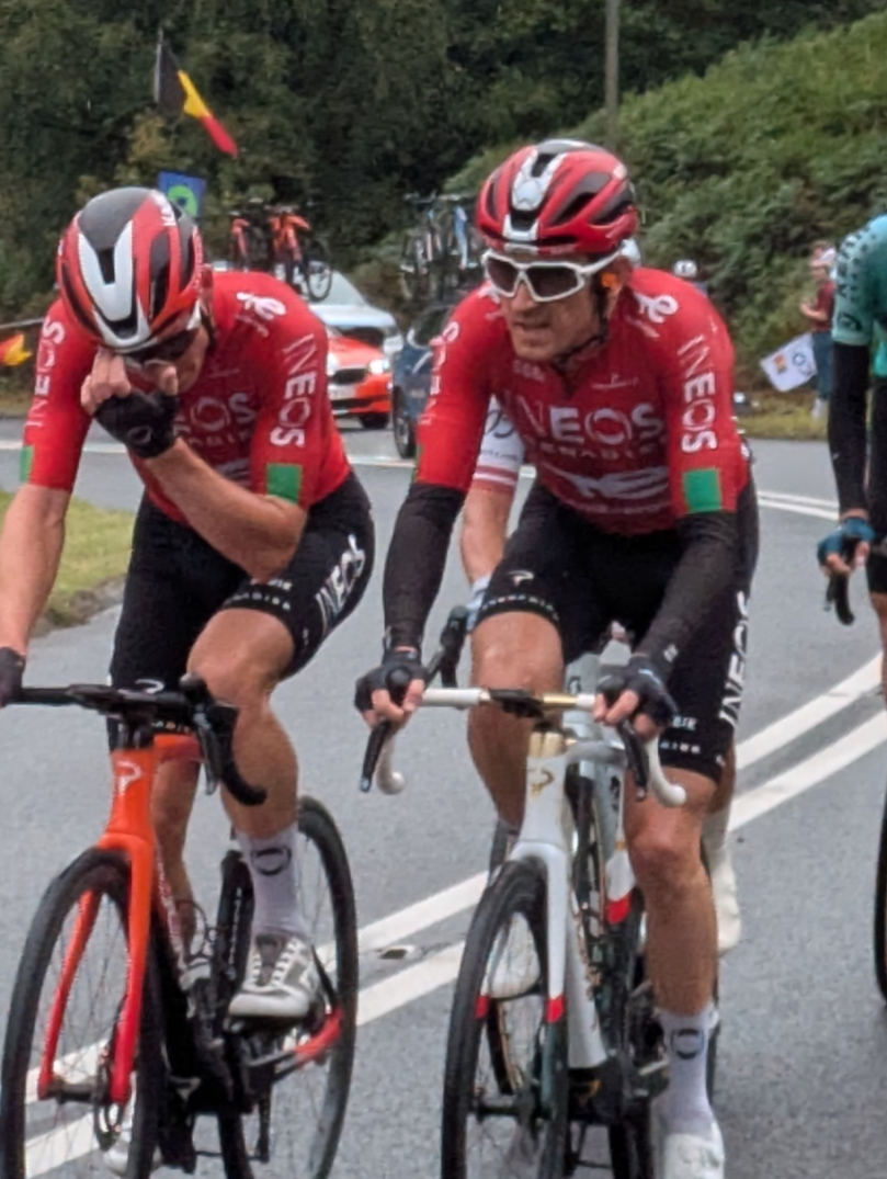 Gruppe professioneller Rennradfahrer mit Geraint Thomas im Vordergrund auf einer Straße in der grünen Landschaft.