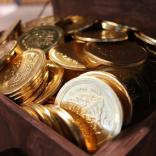 Brand new sparkling one pound coins in a wooden chest.