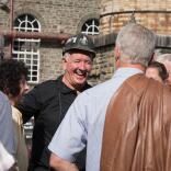 A former miner tour guide laughing with a group of people.