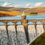 Craig Goch dam and reservoir with autumn colours on the hills beyond in the Elan Valley.