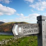 Signpost of Glyndŵr's Way with Clywedog Reservoir and hills in the background