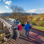 View of two people walking on the Pontcysyllte aqueduct in autumn.