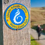 Ein Schild an einem Pfosten mit der Aufschrift Wales Coast Path.