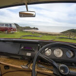 view through campervan windscreen of another campervan near the beach, with Wormshead in view
