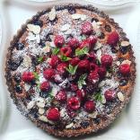 Fresh raspberry and almond flaked fruit tart, dusted with icing sugar. 