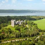 An aerial view of Penrhyn Castle along the Menai Strait and Porth Penrhyn in the background.